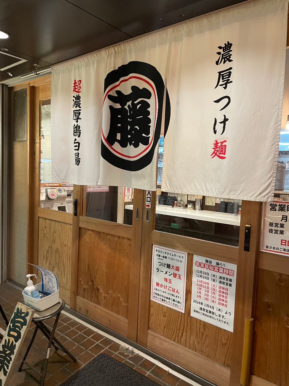 「藤」の字が入った白いのれんが掛かった、木製扉の店の入口。